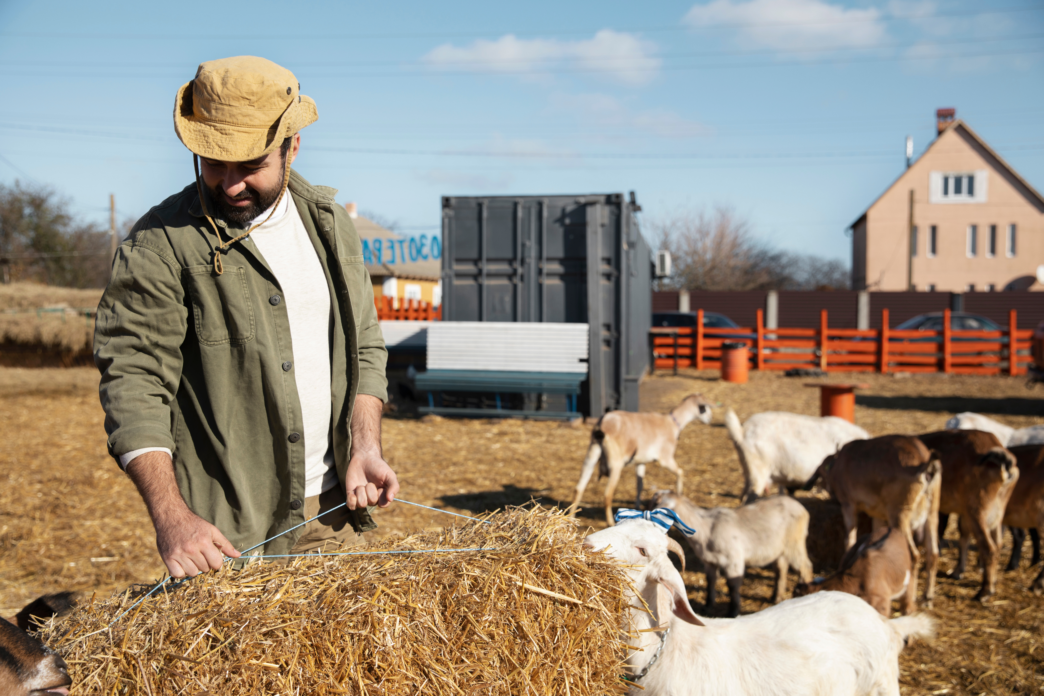 Farm worker near livestock water and feeding equipment